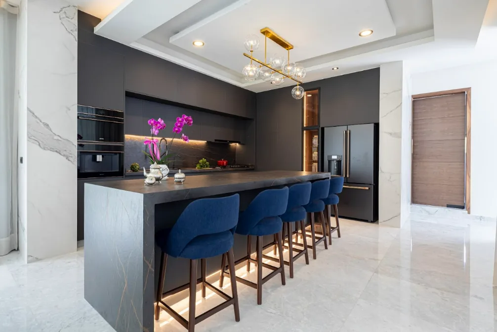 Cocina negra con isla y bancos azules